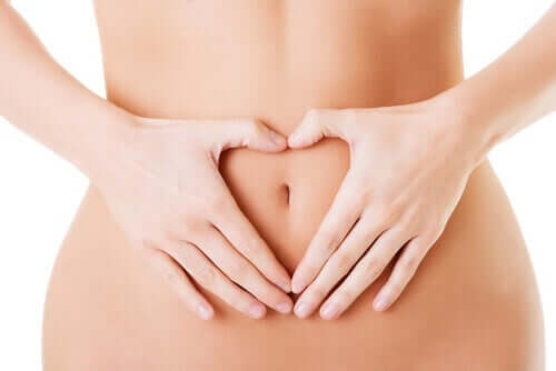 Woman with hands over the digestive system.