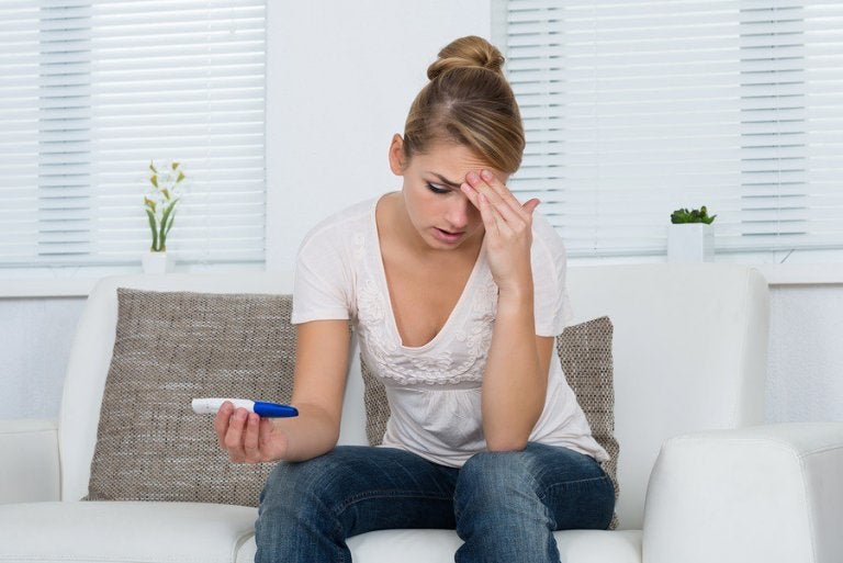 Worried woman after taking a home pregnancy test.