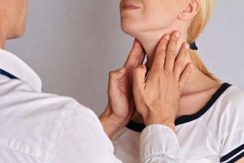 A doctor touching a woman's thyroid.