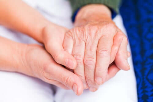 People holding hands, one with the pain of rheumatoid arthritis