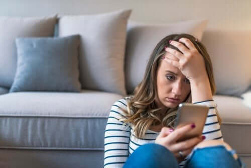 A worried woman using a cell phone.