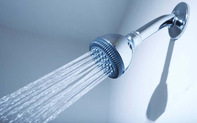 A shower head streaming water.