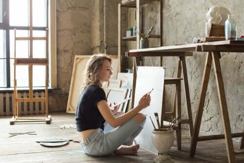 Woman sitting on the floor painting to avoid monotony.