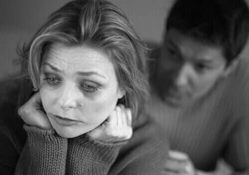 Woman with depression with her partner behind her.
