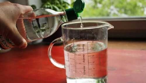 White vinegar being poured into a beaker.