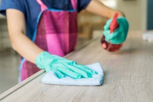 Using white vinegar in a spray bottle to clean wood surfaces.