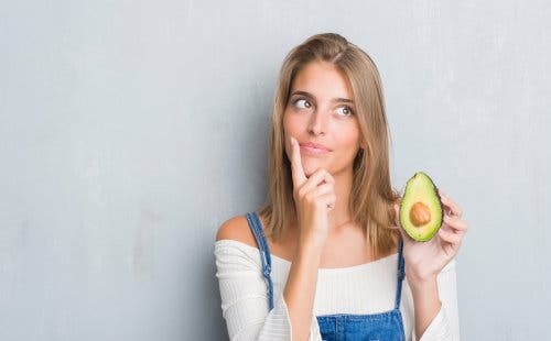 A woman holding an avocado.