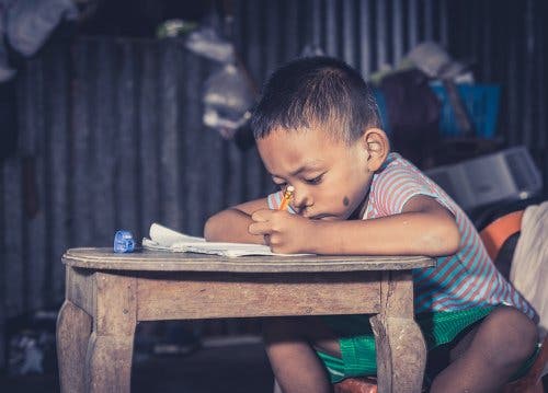 Child writing in notebook.