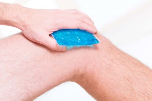 A person putting a cold compress on their knee.