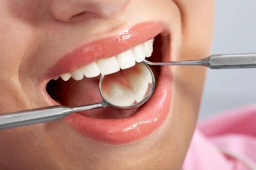 Closeup of a mouth getting checked by a dentist.