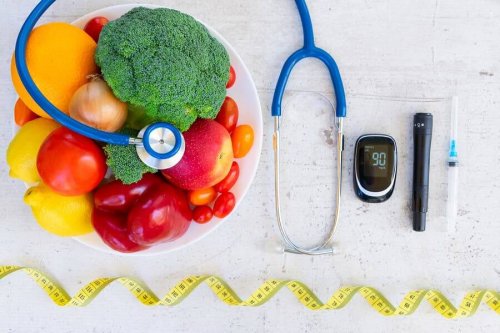 Instruments for diabetes care next to a bowl of fruits and vegetables.