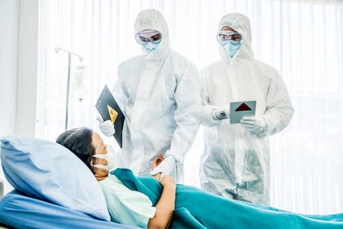 Doctors wearing PPE to see a patient.