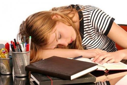 Woman with high ferritin sleeping on desk.