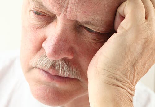 Man with Alzheimer's disease with his head in his hand.