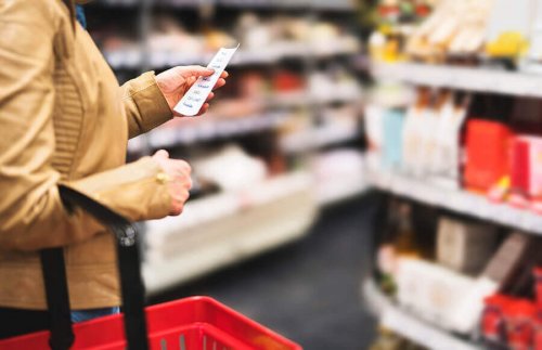 Person at grocery store with shopping list.