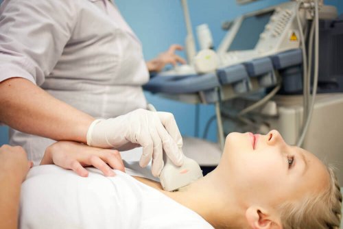 Doctor doing and ultrasound of a woman's thyroid.