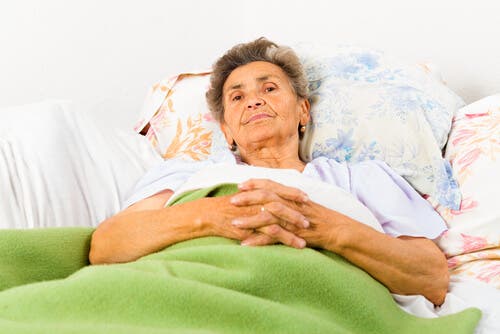 A woman with Alzheimer's disease laying in bed.