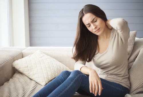 Woman holding neck in pain.