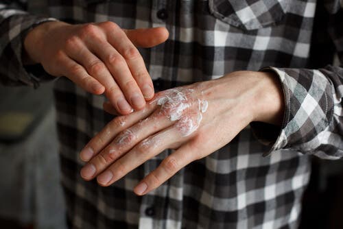 A man applying topical corticosteroids.