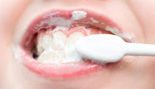 A person brushing their teeth.