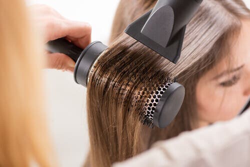 A woman straightening her hair.