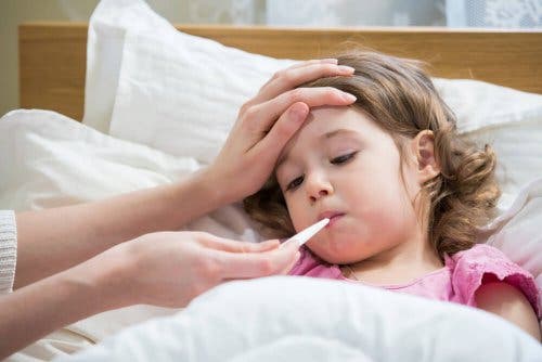 A kid getting her temperature checked for common diseases.