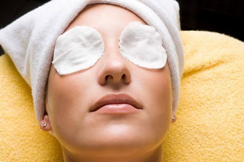 Woman with cold compresses on her eyes.