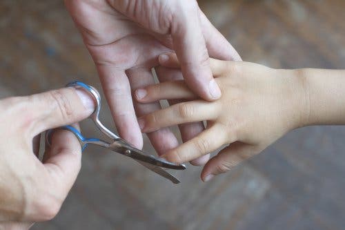 Cutting child's nails to prevent nail biting.