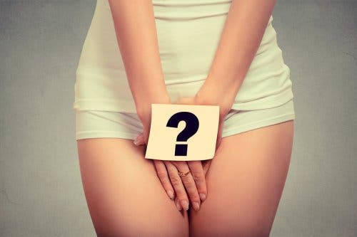 A woman covering groin with hands with "?" sign over them.