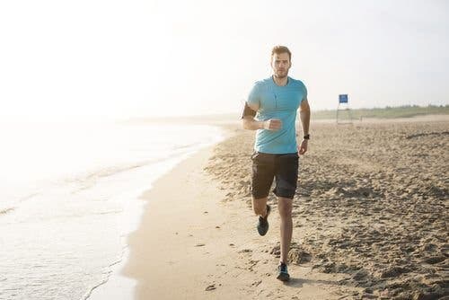 Man running on the beach happy and healthy