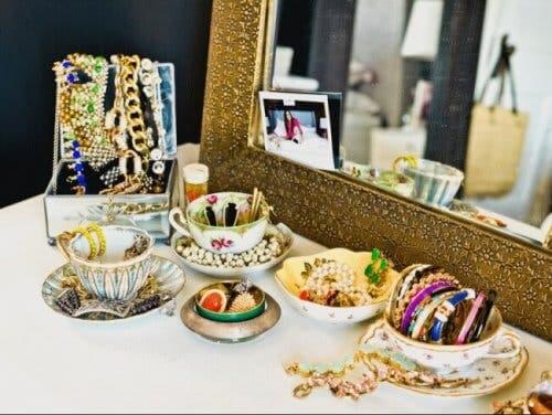 Jewelry on a table in front of a mirror.