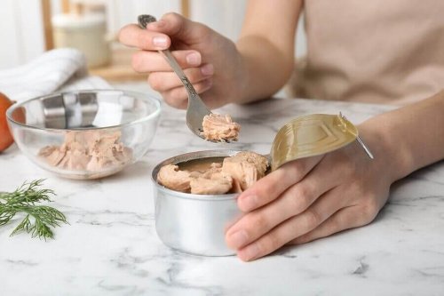 A person eating canned tuna.