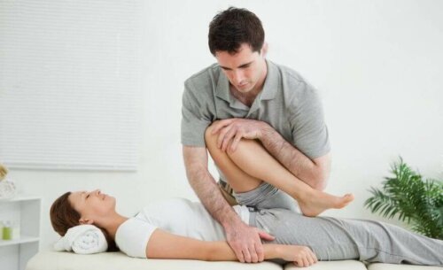 Physical therapist bending woman's leg to treat hip adductor tendinopathy.