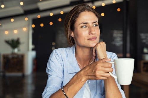 A woman drinking a cup of coffee.