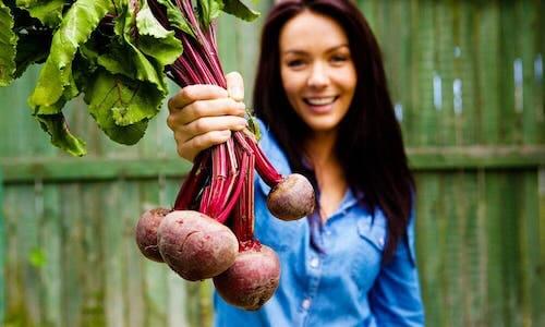 A woman holding beets.