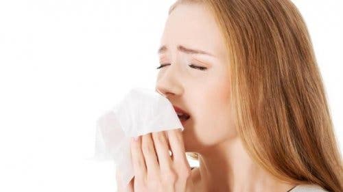 A woman sneezing into a tissue.