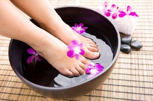 A woman soaking her feet in a basin.