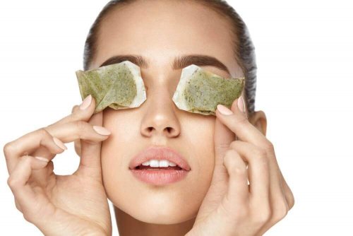 Woman putting tea bags on eyes to reduce eye pain.