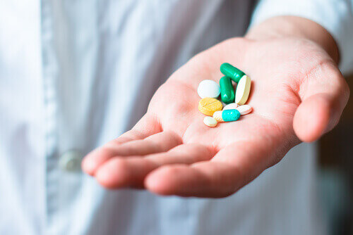 A hand holding pills.