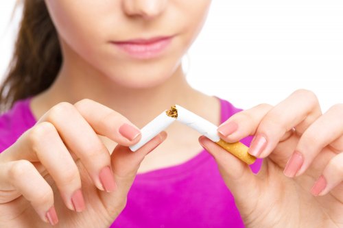 A woman snapping a cigarette.