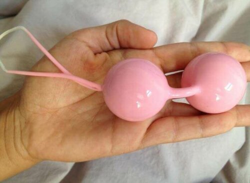 A woman holding a pair of Chinese balls.