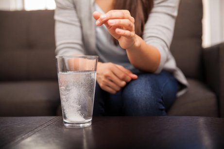 A woman taking an antacid.