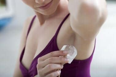 Woman rubbing alum stone under armpit as deodorant.