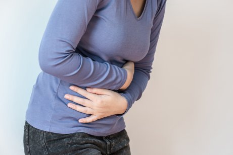 Woman holding stomach in pain.