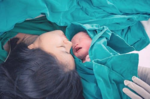 A mother looking at her newborn.