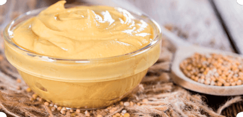 Mustard in a glass cup.