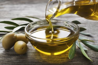 Olive oil pouring into a small bowl.
