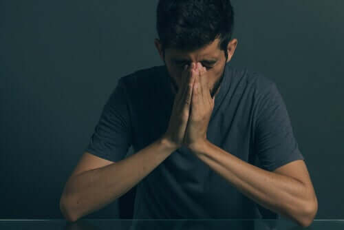 A man with his face in his hands, feeling depression due to a porn addiction.