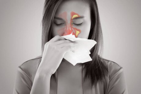 Woman with sinusitis blowing her nose.