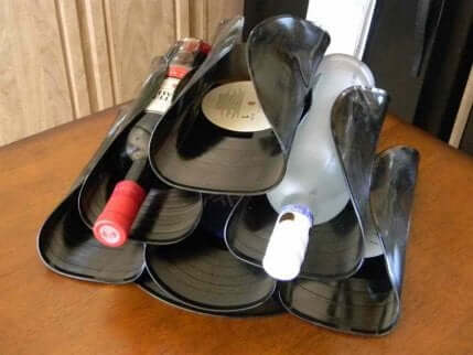 Wine bottle rack made out of vinyl records.